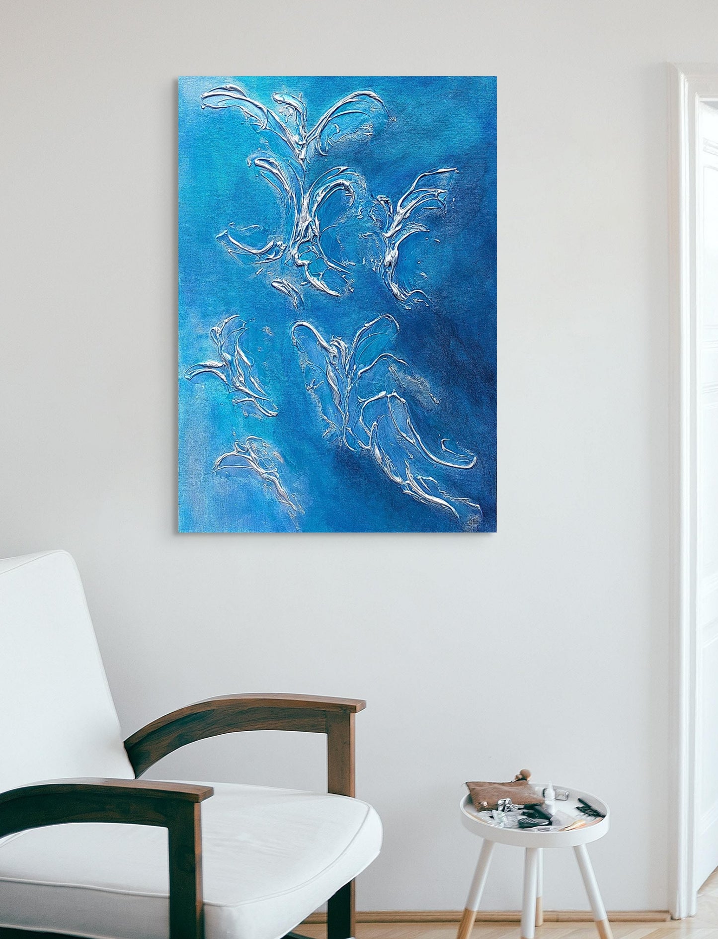 blue acrylic and texture painting hanging above white sofa