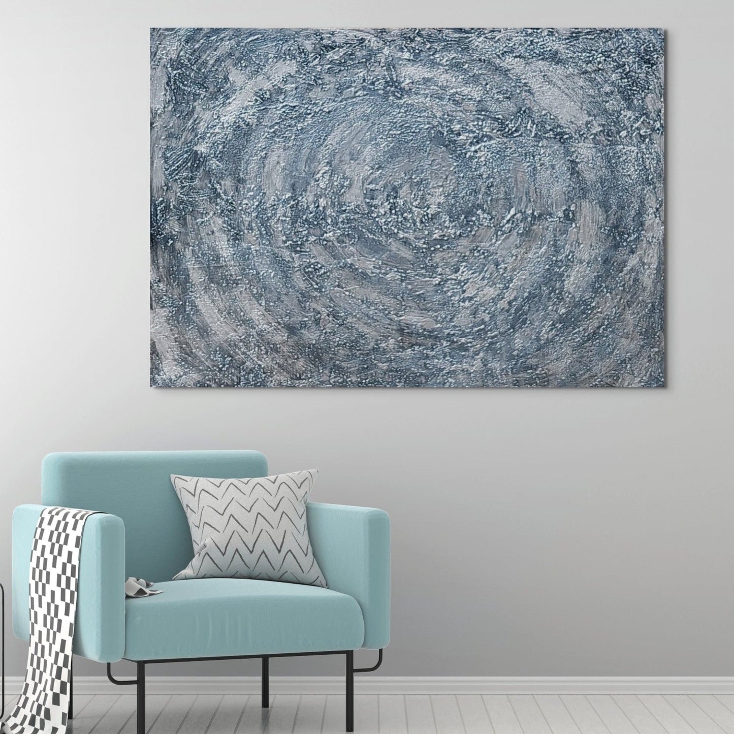 Blue chair in living space. Large black, grey & silver acrylic painting hanging on the wall